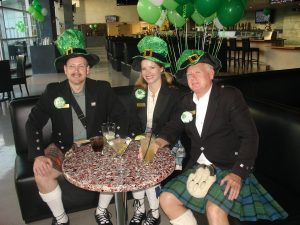Three people in festive St. Patrick's attire.