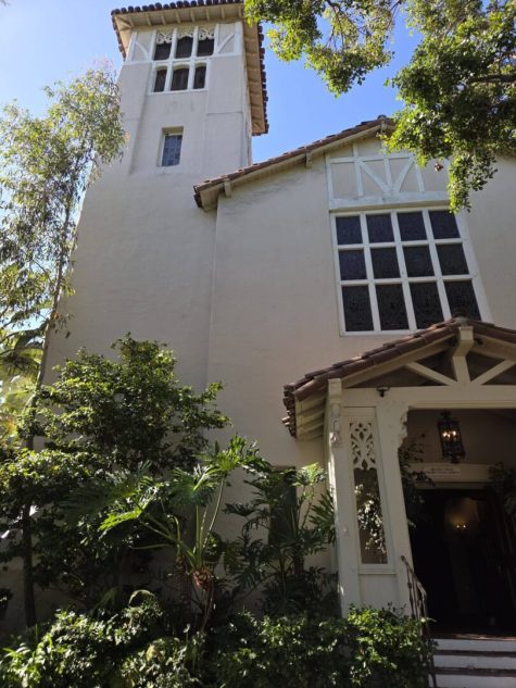 Historic building with greenery and tall tower.